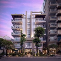 Un hotel con varios balcones, una entrada central y una fachada bien iluminada.