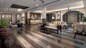 Eine moderne Hotellobby mit einer Rezeption, Sofas und einer großen dekorativen Vase.