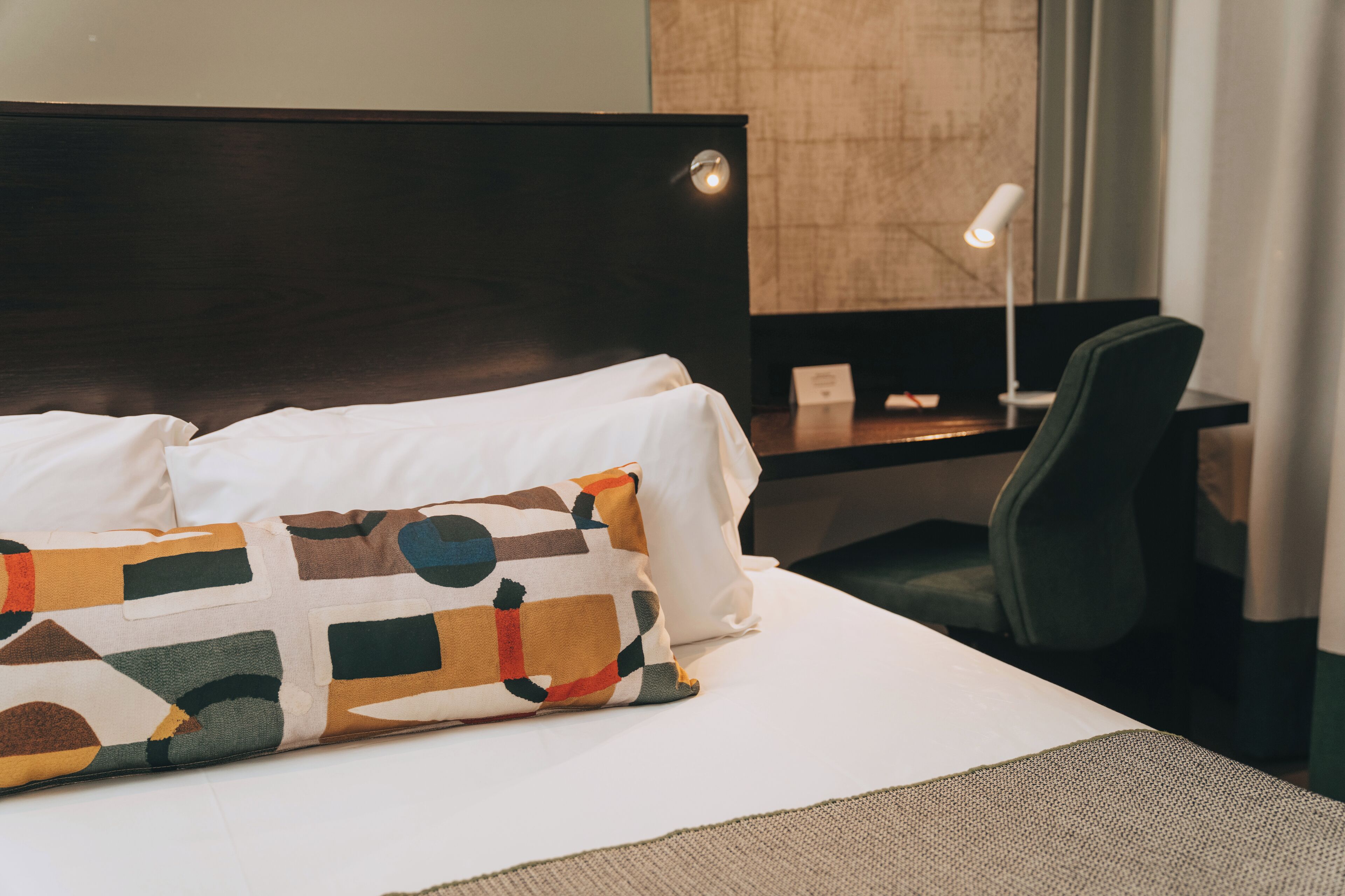 Una habitación de hotel con cama, escritorio y silla.