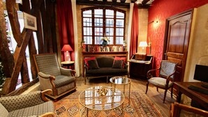 Een gezellige woonkamer met een open haard, een boekenkast en een comfortabele zithoek.