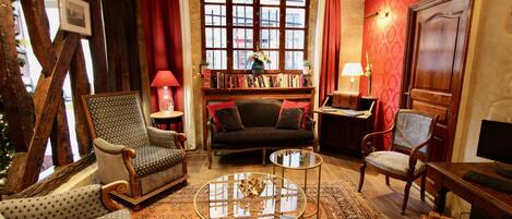 A cozy living room with a fireplace, a bookshelf, and a comfortable seating area.