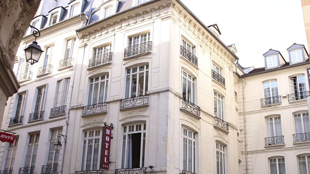 Een hotelgebouw met meerdere balkons, een opvallend 'HOTEL' bord en een 'HB' aanduiding voor de hotelnaam.