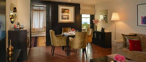 A modern living room with a dining area, featuring a sofa, a coffee table, and a dining table with chairs.