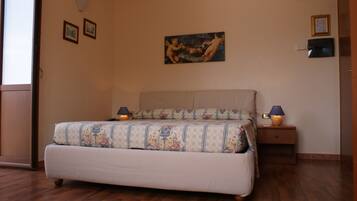 Una camera da letto con un letto, comodini, un quadro appeso al muro e una porta.
