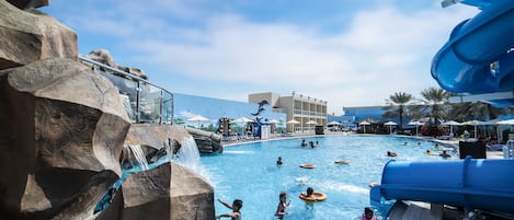 Una piscina techada, una piscina al aire libre, sombrillas