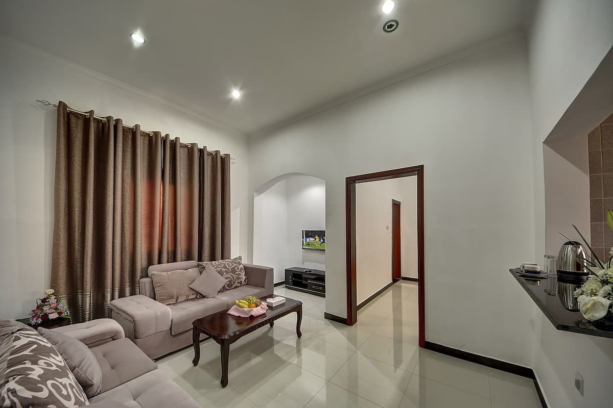 A modern living room with a sofa, coffee table, and curtains.