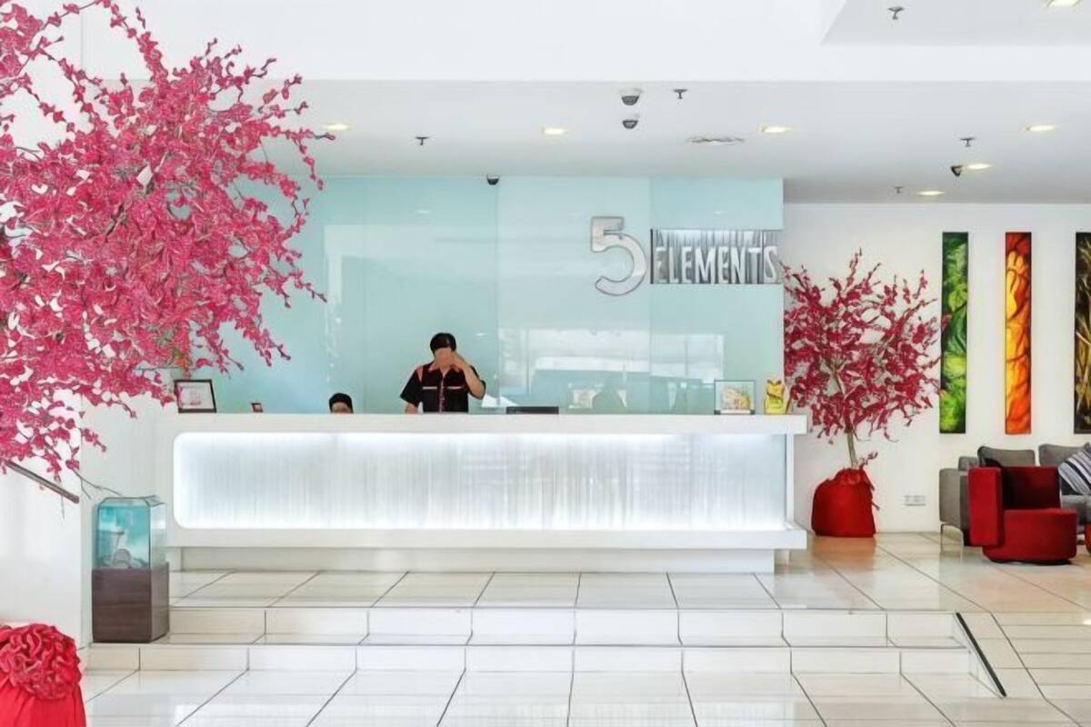 A reception desk with a modern design, a large number '5' sign, and a receptionist.