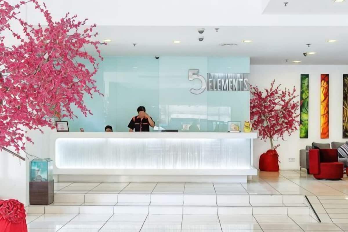 A reception desk with a modern design, a large number '5' sign, and a receptionist.