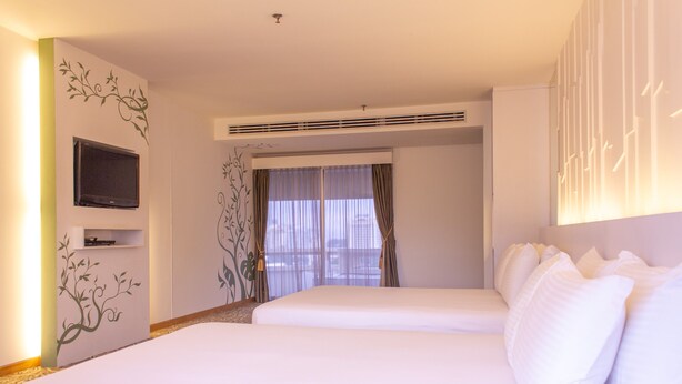 A hotel room with two beds, a flat-screen TV, a large window with curtains, and a decorative wall design. - The 5 Elements Hotel (Kuala Lumpur)