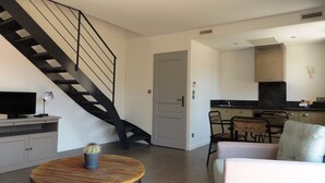 A modern living room with a wooden coffee table, a TV, and a staircase.