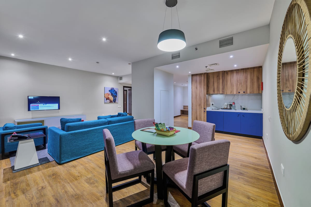 Suite, 1 kingsize bed, balkon, gedeeltelijk uitzicht op zee | Woonruimte | Een flatscreentelevisie