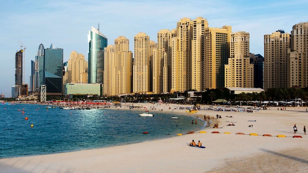 Una playa con edificios altos al fondo.