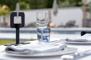 Una mesa de comedor con un vaso de agua, un servilleta doblada y un tenedor.