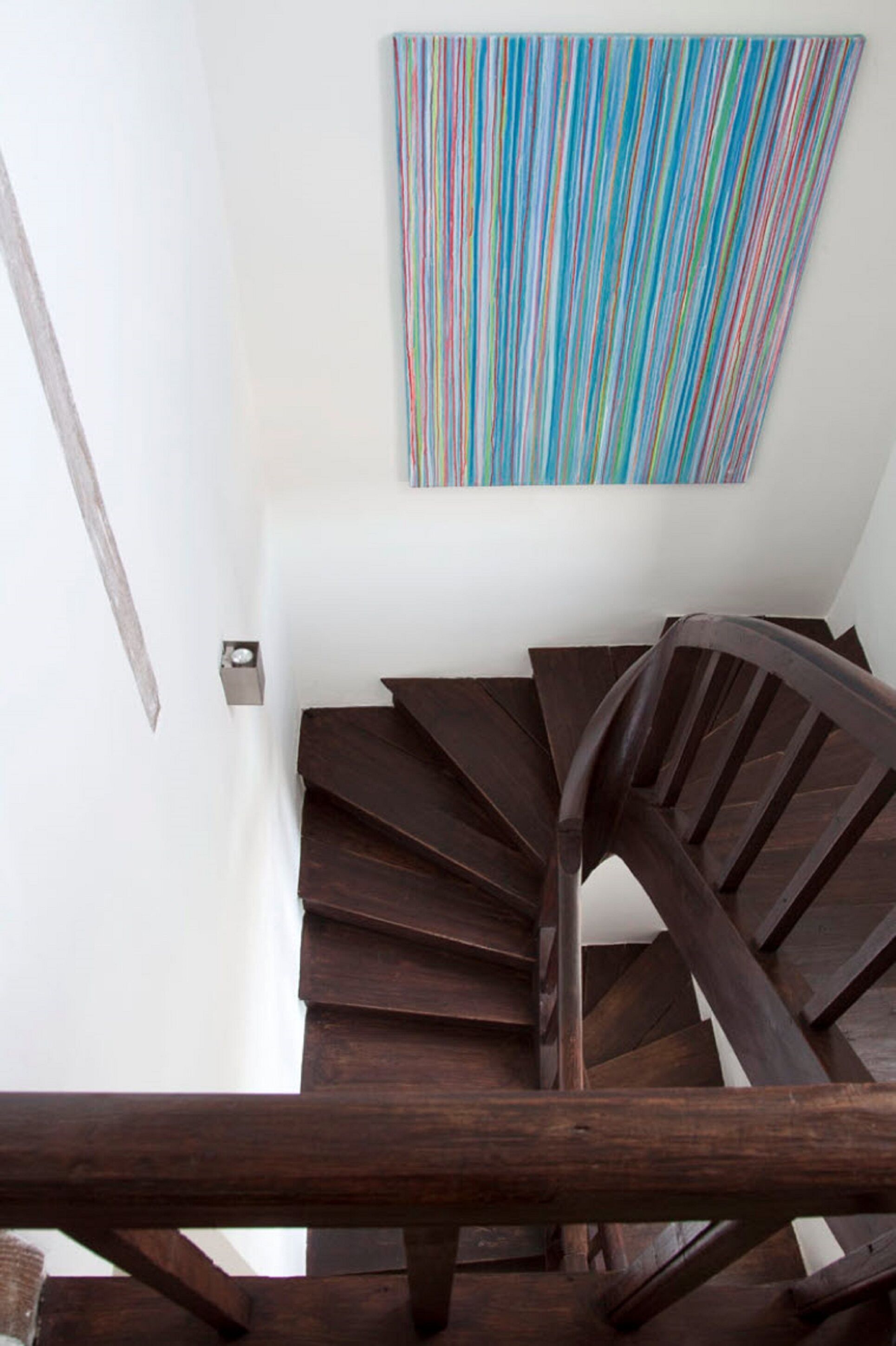A spiral staircase with wooden steps and a dark finish, leading upwards.