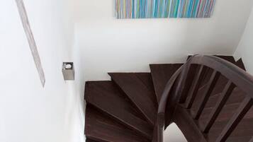 A spiral staircase with wooden steps and a dark finish, leading upwards.