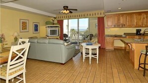 Un salon avec un canapé, un téléviseur et un balcon offrant une vue agréable.