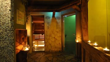 Stroll through this charming hallway with a stone floor and wooden beams, featuring a green door and a wall-mounted sign.