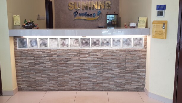 A reception desk with a 'SUNNINGS' sign, a clock, and a card slot. - Sun Inns Hotel Bandar Puchong Utama (Puchong)