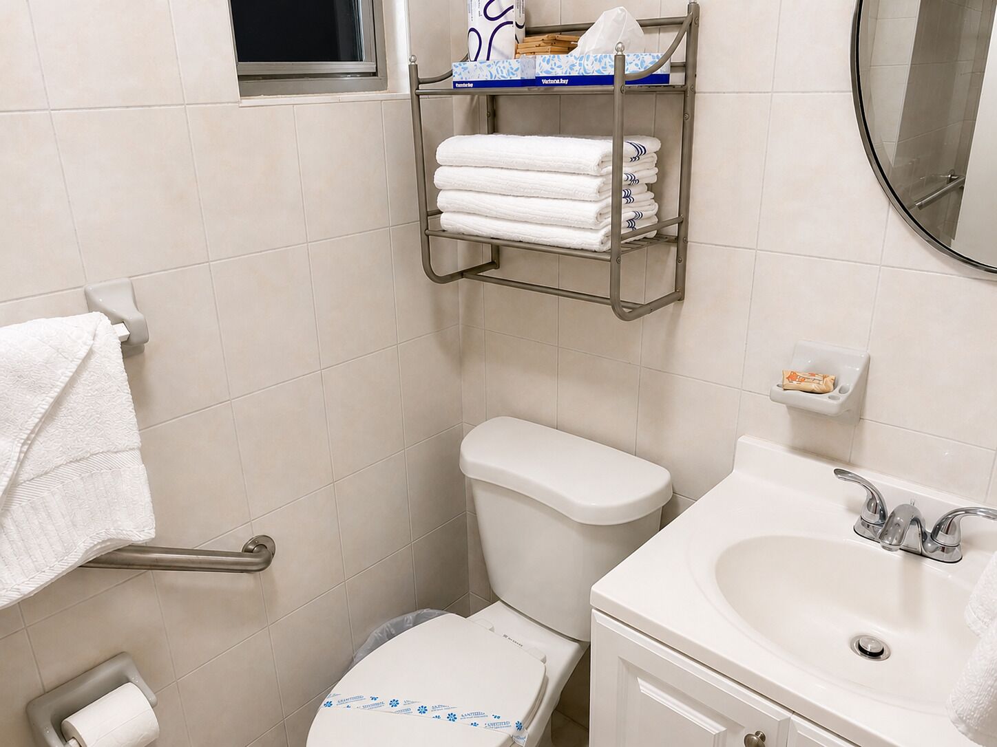 Une salle de bain équipée de toilettes, d’un lavabo et d’un porte-serviettes.