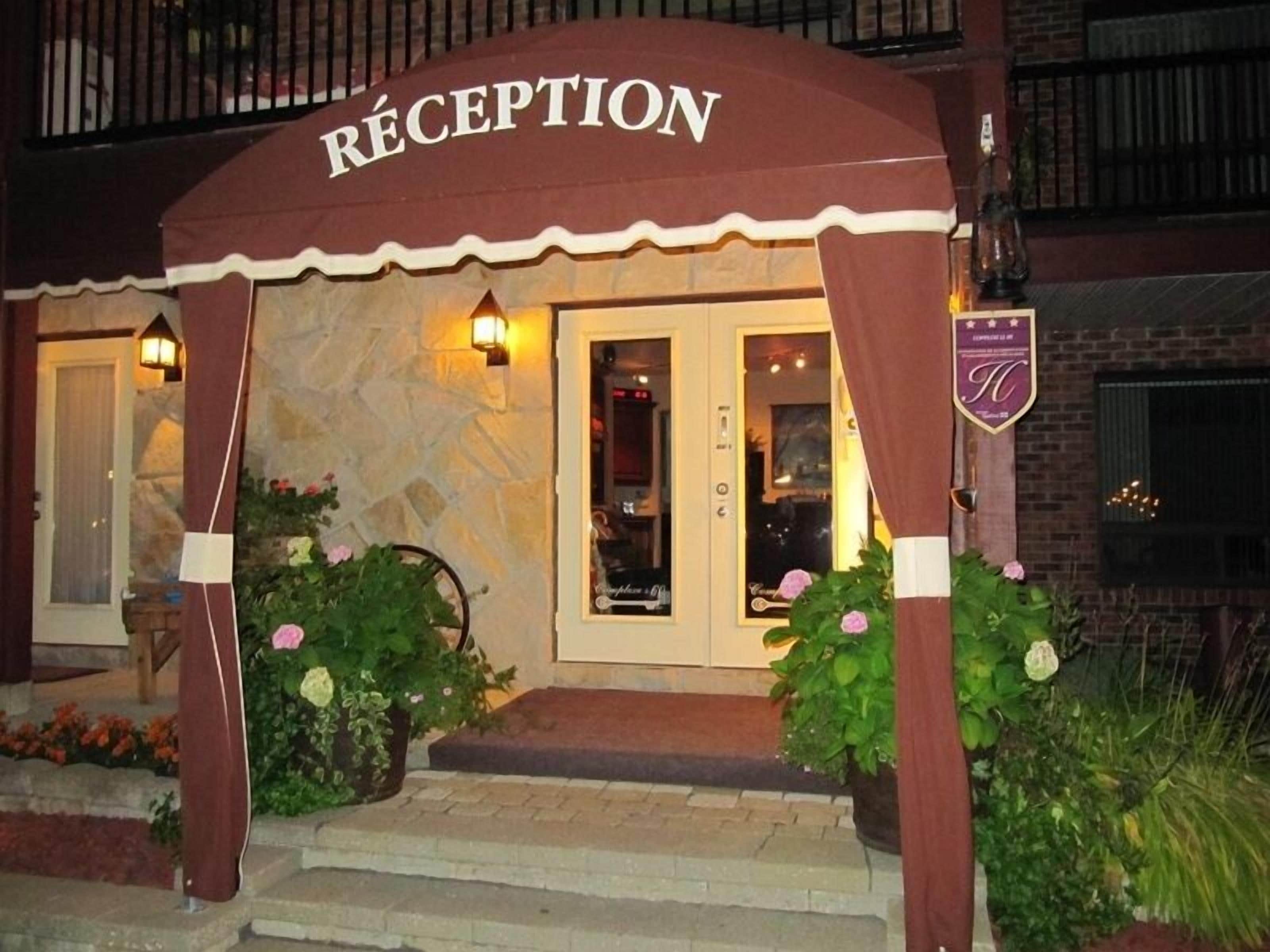 A reception area with a stone facade, a sign reading "RECEPTION," and a small garden with pink flowers.