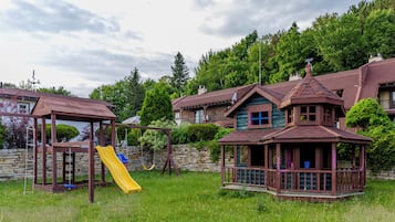 Una zona residencial con un parque infantil, un mirador y casas con tejados inclinados.