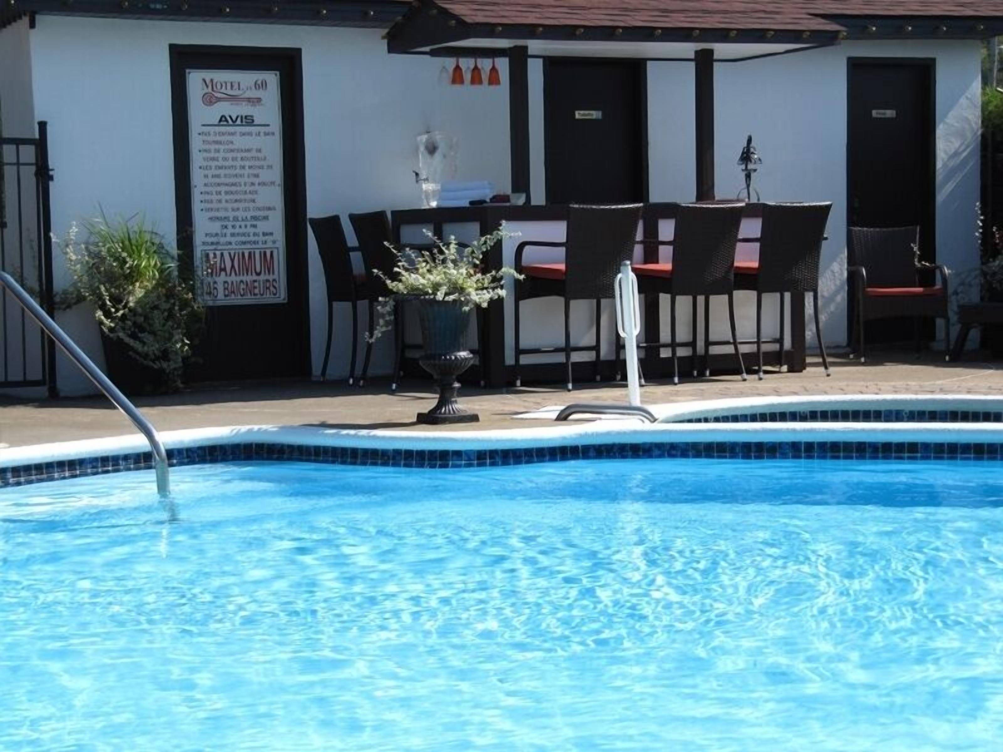 A swimming pool with a signboard for a motel and a maximum occupancy sign.