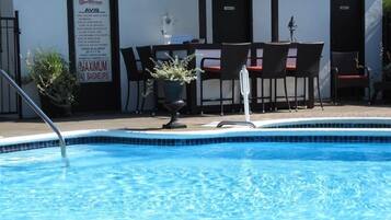 A swimming pool with a signboard for a motel and a maximum occupancy sign.