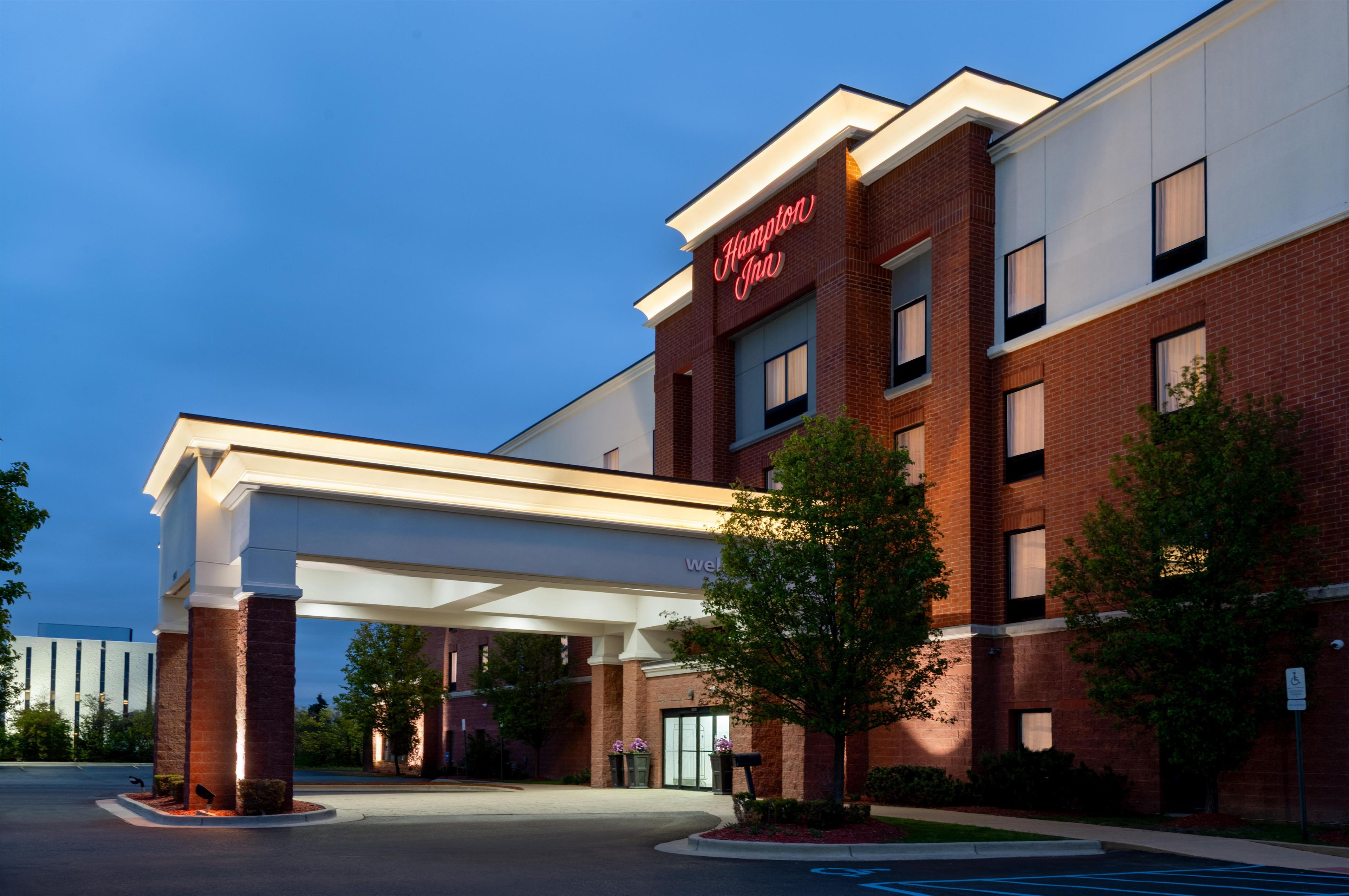 A brick building with a large overhang and a sign that reads 'Hampton Inn.'
