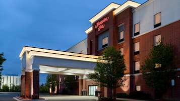 A brick building with a large overhang and a sign that reads 'Hampton Inn.'