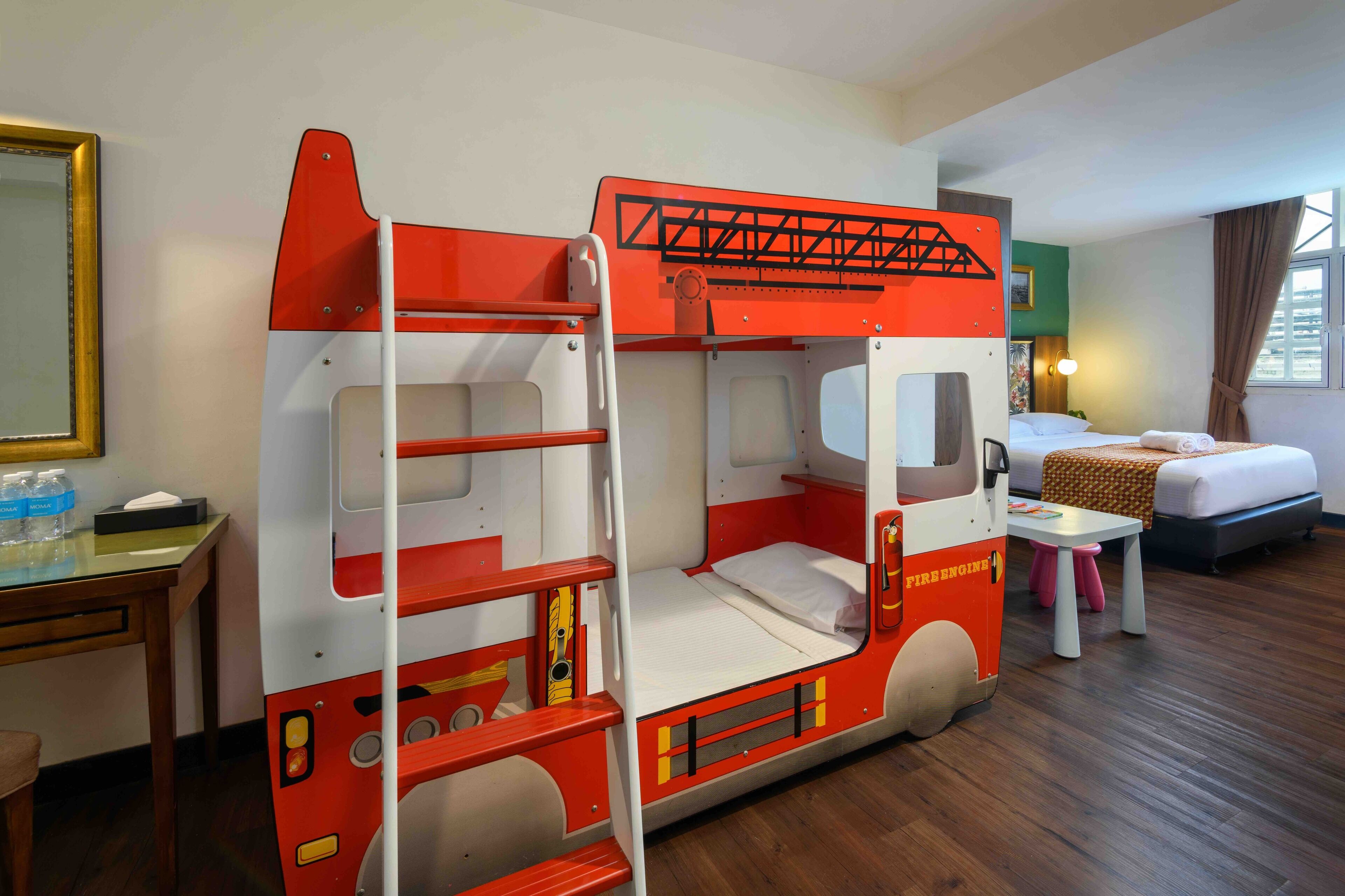 A room with a bunk bed and a fire engine-themed bed.
