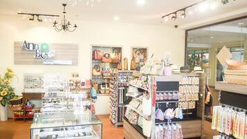 A jewelry store with glass display cases, shelves of handbags, and a sign reading "Ann Bees".