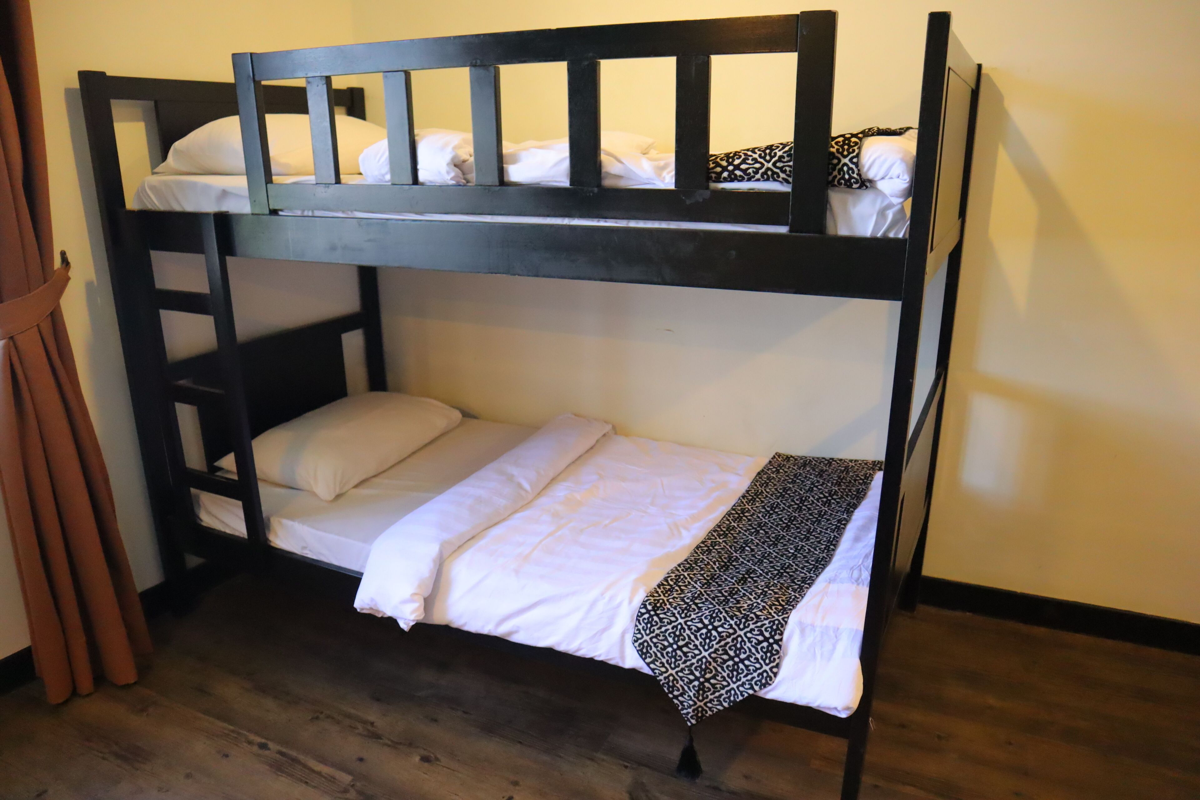 Ein Stockbett mit weißer Bettwäsche und einer gesteppten Decke.