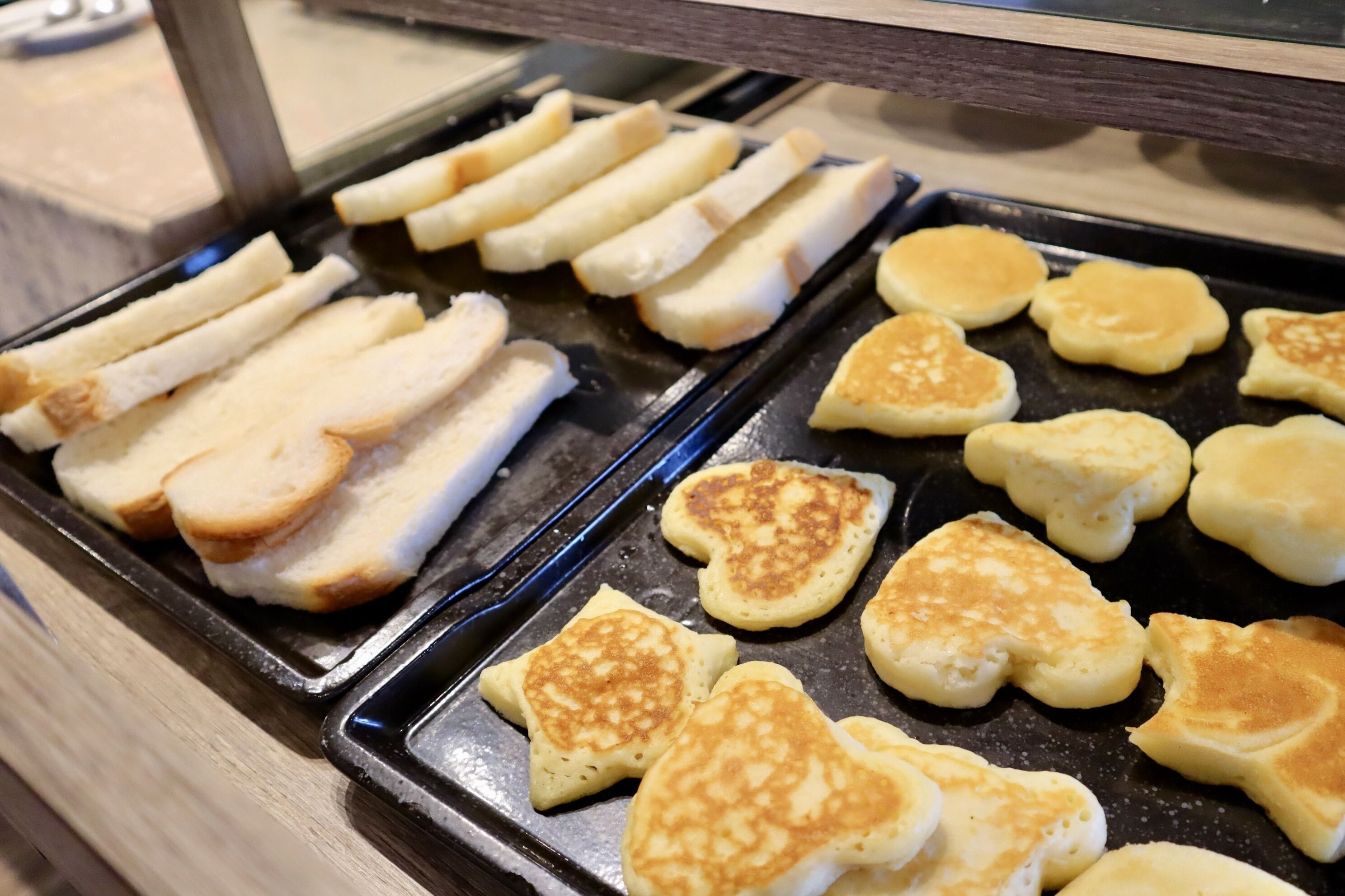 Bandeja de café da manhã com panquecas e fatias de pão.
