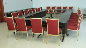 A conference room with a long table and red chairs. - Aphrodite International Hotel (Addis Ababa)