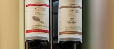 Drei Flaschen Haarpflegeprodukte von Damana Apothicals auf einem Regal.