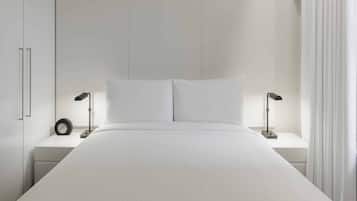 Un dormitorio moderno con una cama grande, dos mesitas de noche y un tocador.