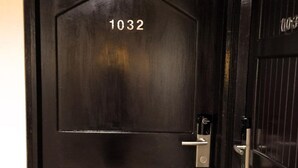 Una puerta de madera oscura con el número 1032.