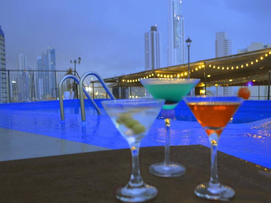 Una piscina al aire libre, sombrillas, sillones reclinables de piscina