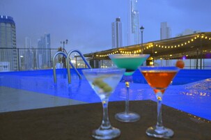 Una piscina al aire libre, sombrillas, sillones reclinables de piscina