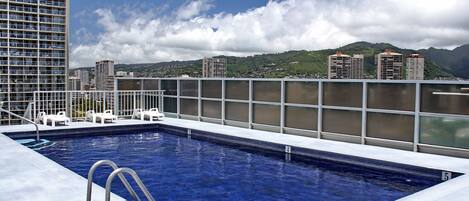 Une piscine offrant une vue sur le paysage urbain et les montagnes.