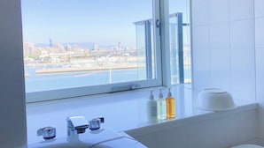 A bathroom with a large window, a sink, and toiletries. - Hotel Marinoa Resort Fukuoka (Fukuoka)