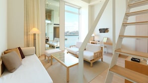 A modern hotel room with a sofa, two armchairs, a small table, a desk, and a staircase. - Hotel Marinoa Resort Fukuoka (Fukuoka)