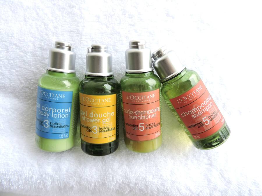 Four bottles of L'OCCITANE body care products.