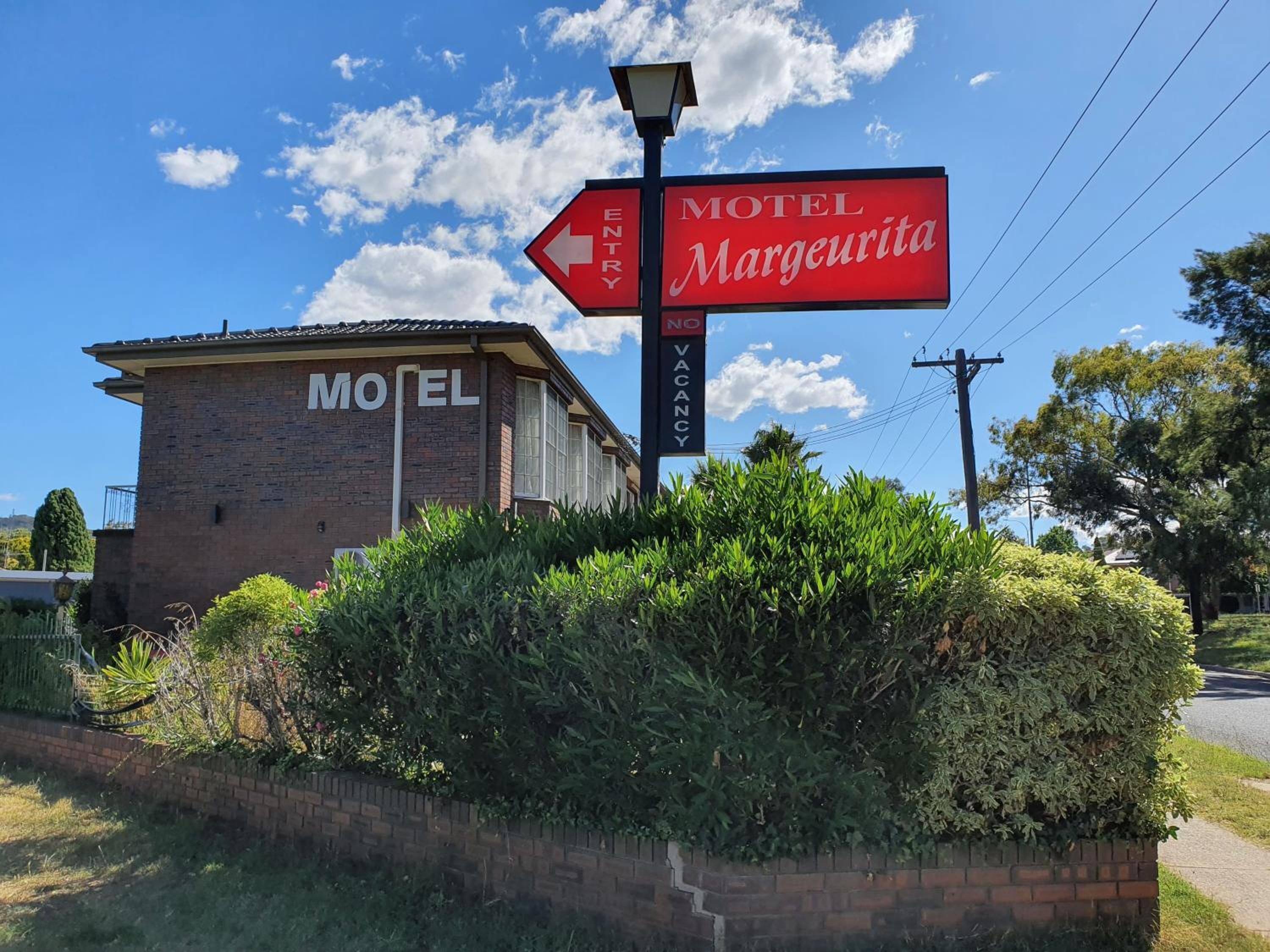 Un motel llamado 'Motel Marguerita' con un cartel que indica 'No hay habitaciones disponibles'.