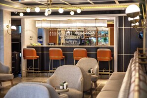 A bar area with bar stools, a counter, and a seating area with sofas and chairs. - Bentley Hotel Bosphorus - Special Class (Istanbul)