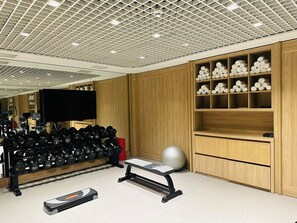 A gym with weightlifting equipment, a bench, and a wall with neatly stacked towels. - Bentley Hotel Bosphorus - Special Class (Istanbul)