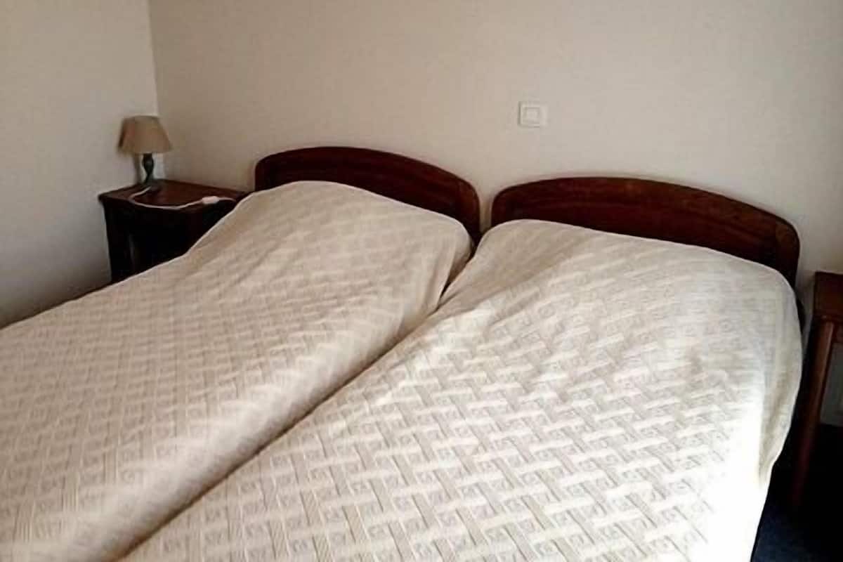 Uma cama de casal com colcha estampada em um quarto de hotel.