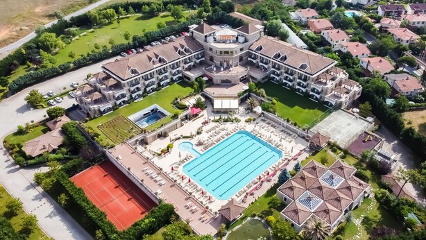 An aerial view of a large hotel with multiple buildings, a central swimming pool, tennis courts, and landscaped gardens. - The Sign Şile Hotel & Spa (Sile)