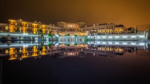 A hotel with multiple floors and balconies, reflecting on a calm body of water. - The Sign Şile Hotel & Spa (Sile)