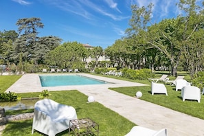 A swimming pool with lounge chairs and a grassy area. - Logis Hôtel L'hermitage (Pernes-les-Fontaines)